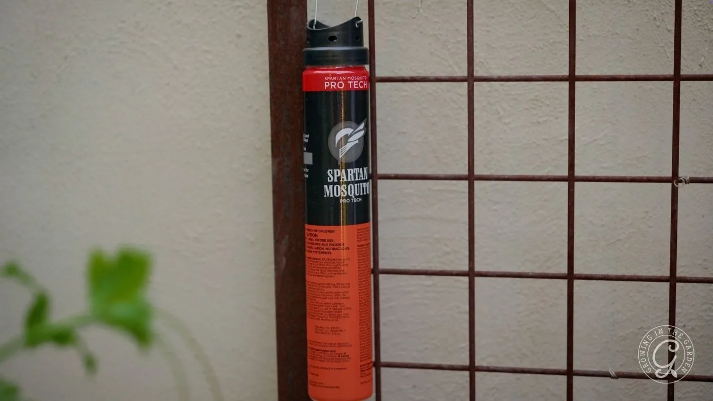 A can of Spartan Mosquito spray is placed upright against a metal grid and beige wall.