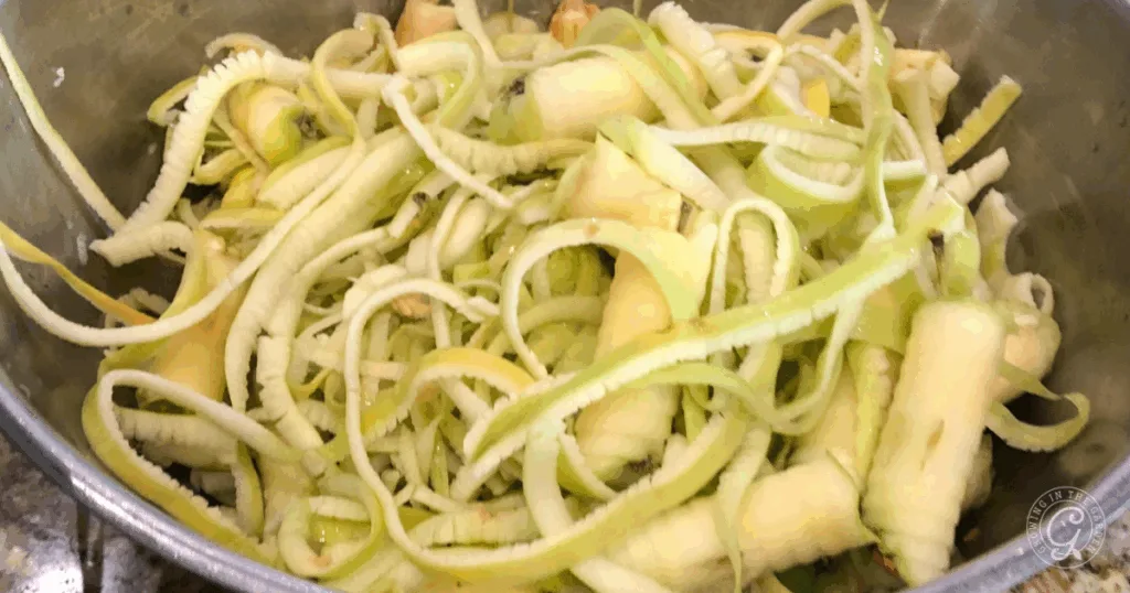 A bowl filled with peeled and spiralized apple skins and cores, perfect for using in the best recipes for Anna apples.