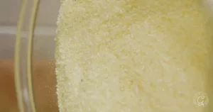 Close-up of dry granulated gelatin in a glass bowl, perfect for experimenting with new textures in the kitchen or pairing with the best recipes for okra.