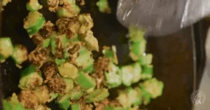 Chopped okra being saut&eacute;ed in a pan, some pieces are browned and crispy&mdash;perfect for those seeking the Best Recipes for Okra.