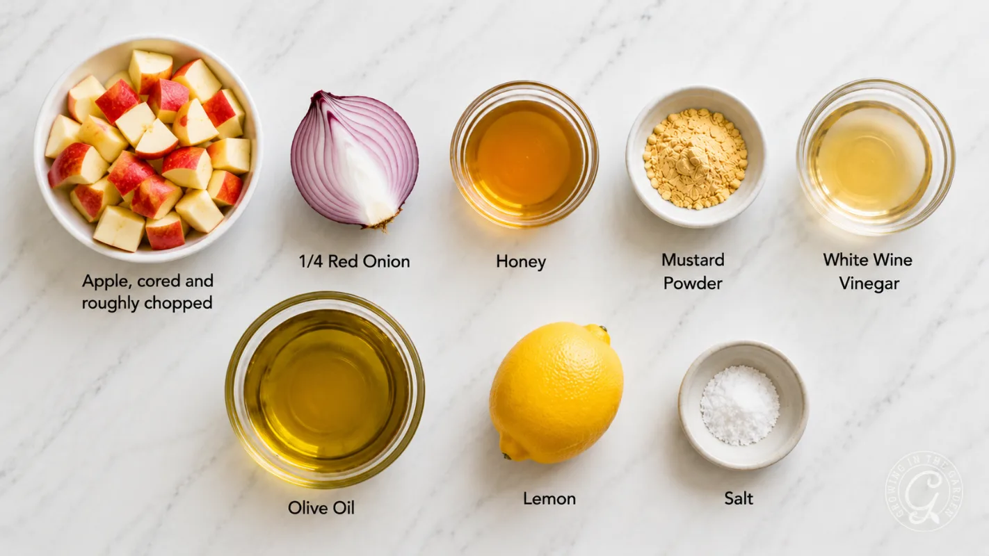 Chopped apples, red onion, honey, mustard powder, vinegar, olive oil, lemon, and salt on a marble surface.