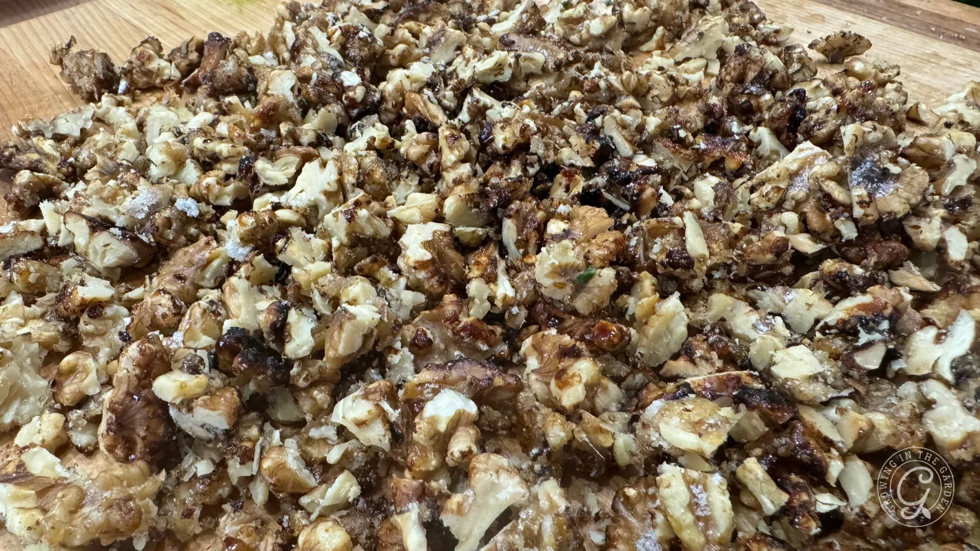 Chopped walnuts spread out on a wooden surface.
