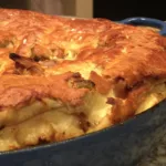 A golden brown apple Dutch baby pancake in a blue cast iron skillet.